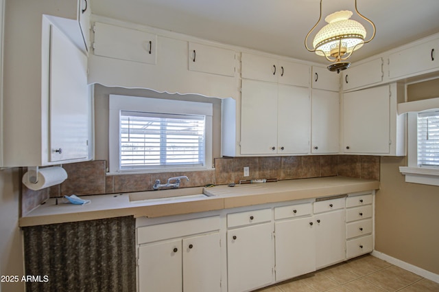 kitchen with white cabinetry, sink, and decorative light fixtures