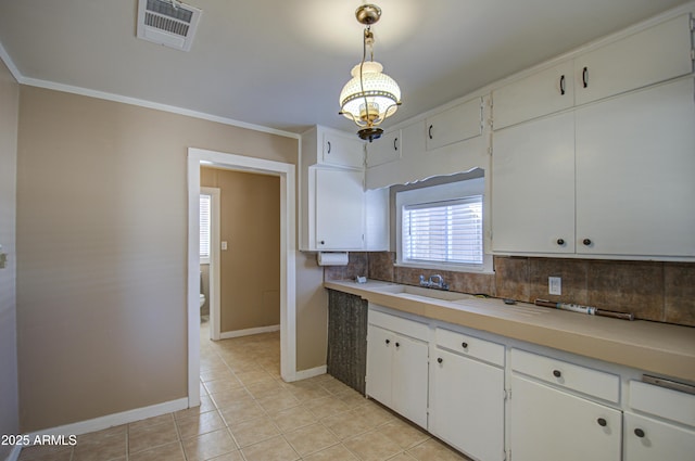 kitchen featuring light tile patterned flooring, sink, white cabinetry, hanging light fixtures, and decorative backsplash