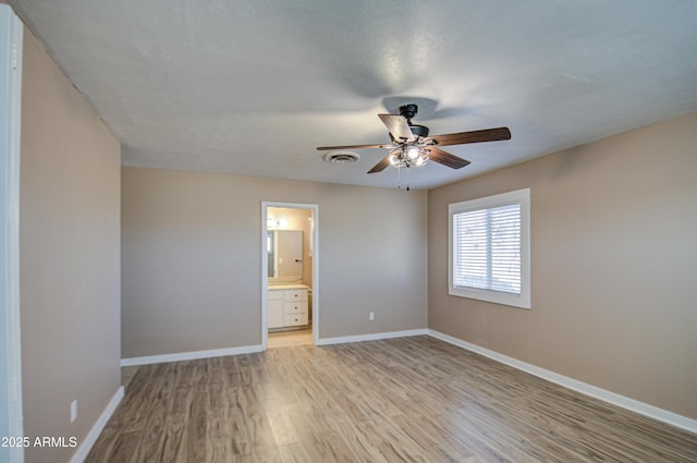 unfurnished bedroom featuring ceiling fan, ensuite bath, and light hardwood / wood-style floors