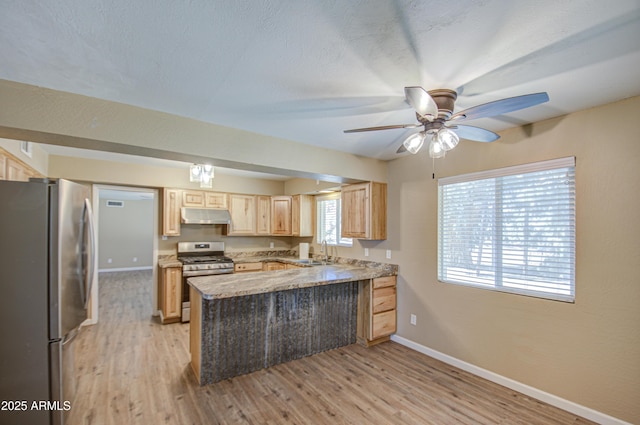 kitchen with sink, light hardwood / wood-style flooring, stainless steel appliances, light brown cabinetry, and kitchen peninsula