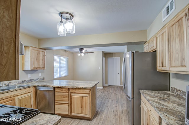 kitchen featuring ceiling fan, appliances with stainless steel finishes, light brown cabinetry, kitchen peninsula, and light wood-type flooring