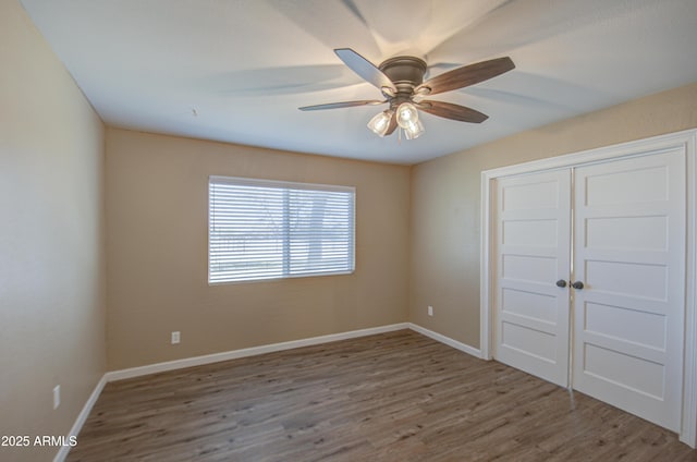 unfurnished bedroom with hardwood / wood-style flooring, a closet, and ceiling fan