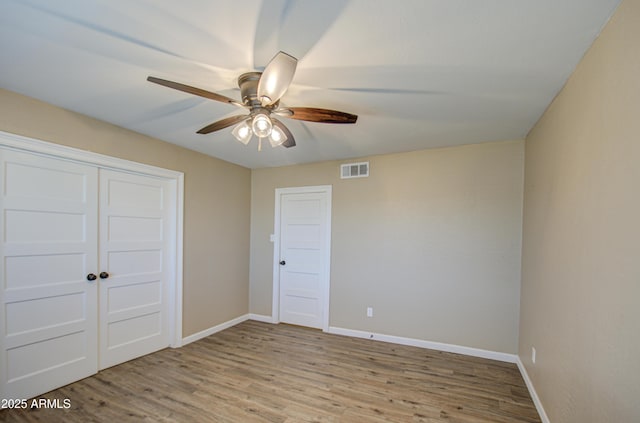 unfurnished bedroom with light hardwood / wood-style flooring, a closet, and ceiling fan