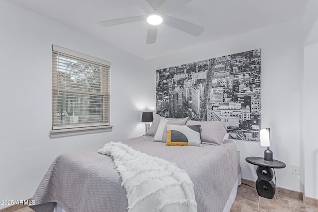 bedroom with a ceiling fan and stone finish floor