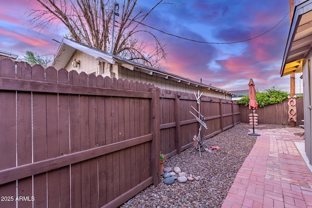 yard at dusk with a fenced backyard