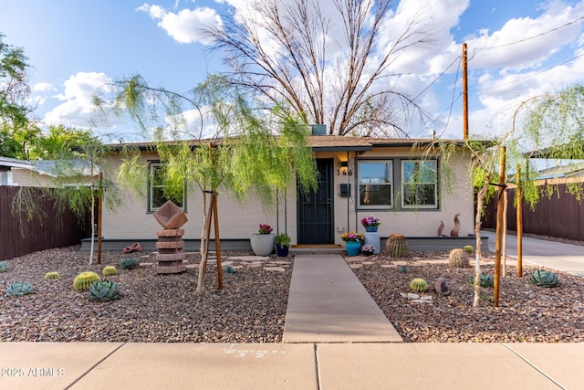 ranch-style home featuring fence