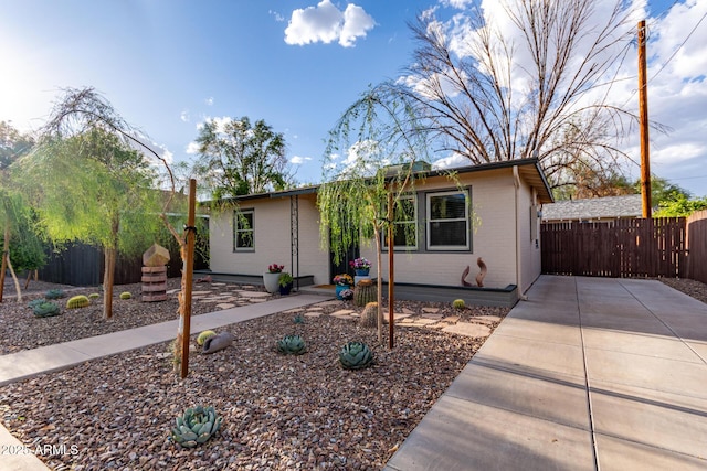 view of front of home with brick siding and fence