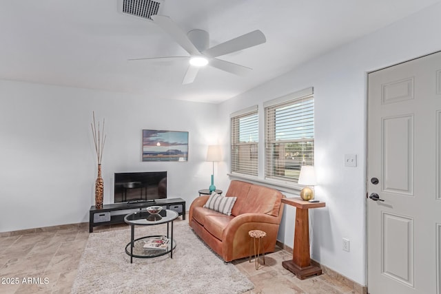 living area with visible vents, baseboards, ceiling fan, and stone finish floor
