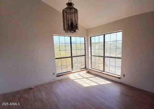 unfurnished dining area with wood finished floors and lofted ceiling