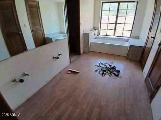 bathroom featuring a bath and wood finished floors