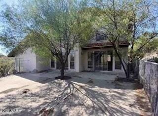 back of property featuring a patio area and fence