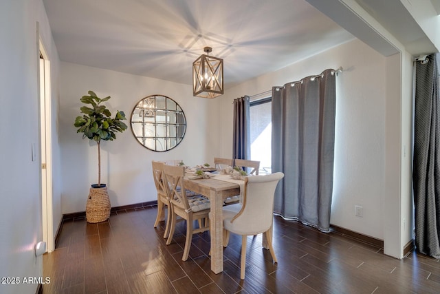 dining area with dark hardwood / wood-style flooring and a chandelier