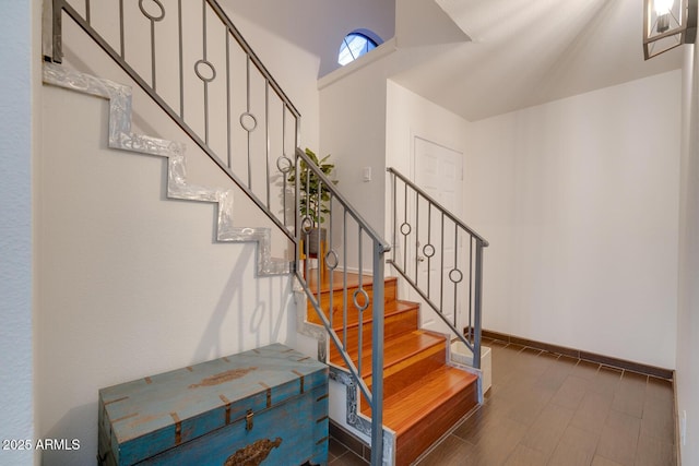 stairway featuring lofted ceiling and hardwood / wood-style floors