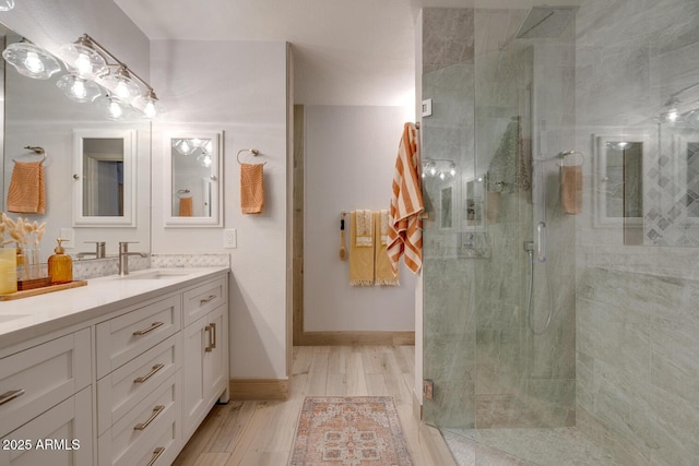 bathroom with hardwood / wood-style flooring, vanity, and an enclosed shower