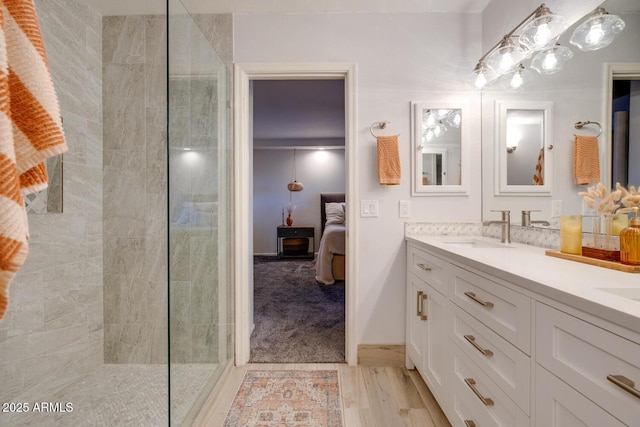 bathroom featuring vanity, hardwood / wood-style floors, and tiled shower