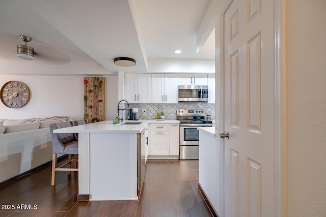 kitchen featuring stainless steel appliances, dark hardwood / wood-style flooring, sink, and white cabinets