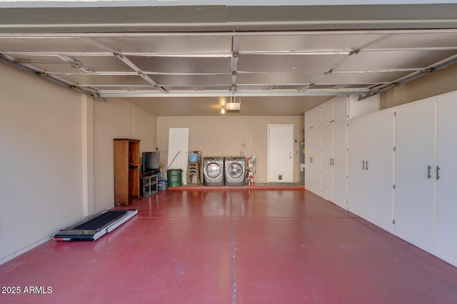 garage with a garage door opener and washer and dryer