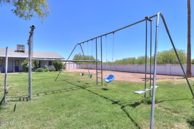 view of home's community with an outdoor structure, a playground, a shed, a lawn, and fence