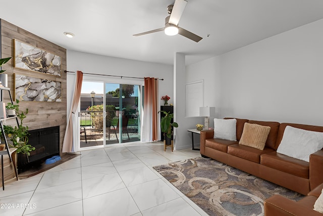 living room featuring ceiling fan and a tile fireplace