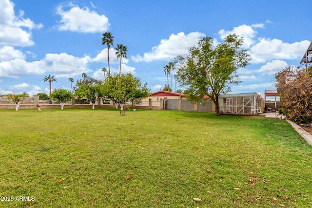 view of yard featuring an outdoor structure and fence