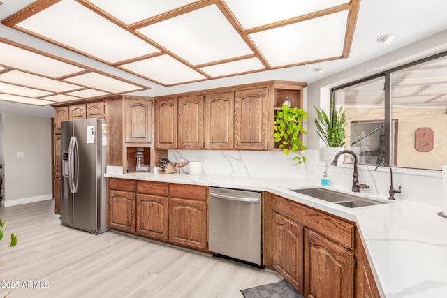 kitchen with a sink, stainless steel appliances, and brown cabinetry