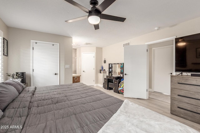 bedroom with visible vents, light wood-style flooring, and a ceiling fan