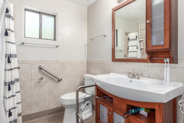 bathroom featuring vanity, a shower with shower curtain, wainscoting, tile walls, and toilet