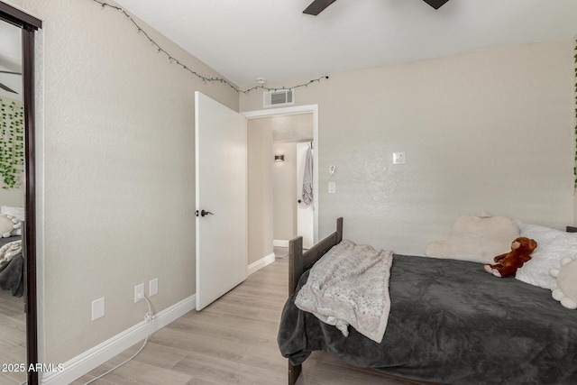 bedroom with visible vents, baseboards, light wood-style floors, and ceiling fan