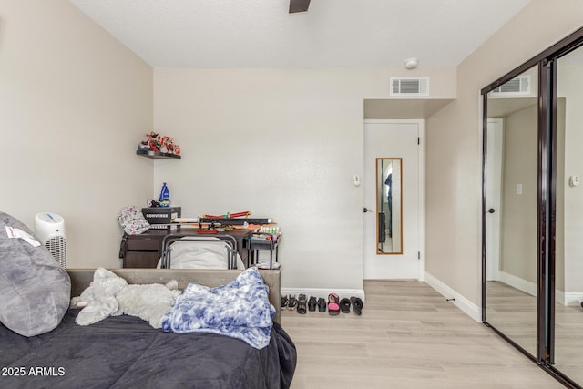 bedroom featuring visible vents, ceiling fan, baseboards, and wood finished floors