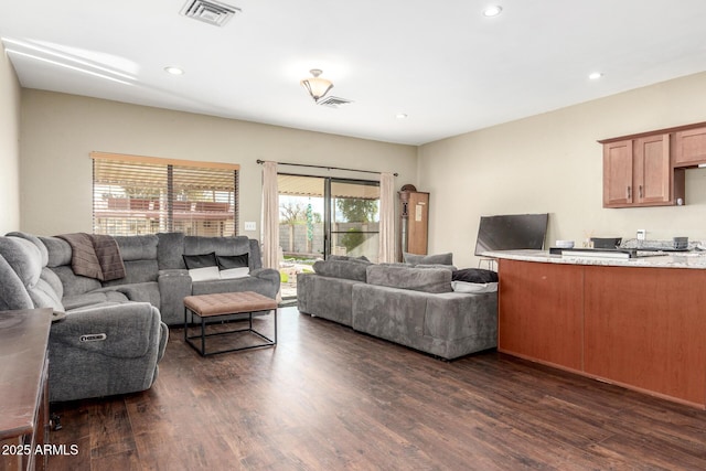 living room with visible vents, recessed lighting, and dark wood-type flooring