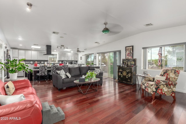 living area featuring visible vents, dark wood-type flooring, ceiling fan, and vaulted ceiling