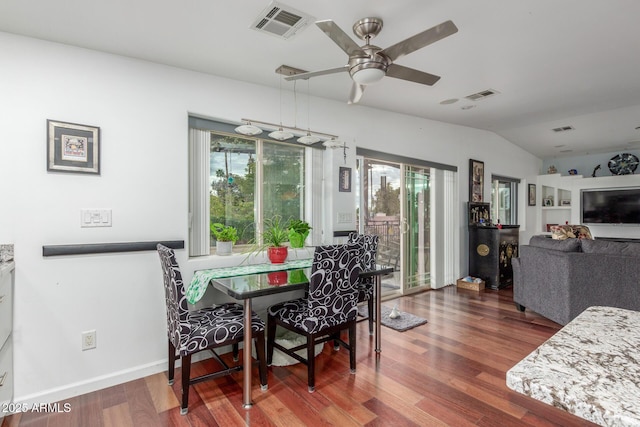 dining space with visible vents, a ceiling fan, lofted ceiling, and wood finished floors