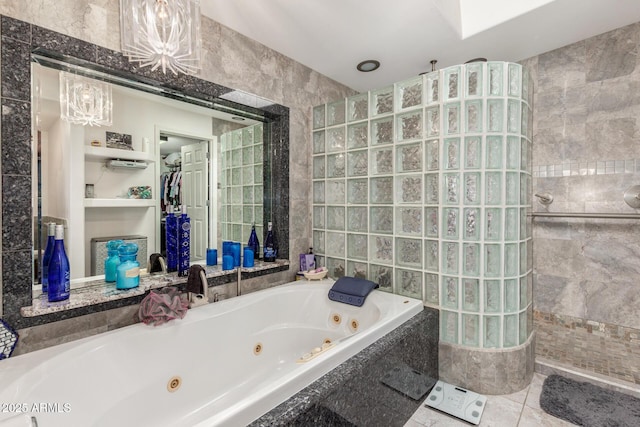 bathroom with tile patterned floors, tile walls, walk in shower, and a whirlpool tub