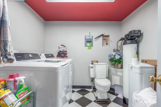 clothes washing area featuring tile patterned floors, laundry area, baseboards, and washing machine and clothes dryer