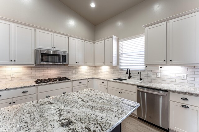 kitchen with white cabinets, appliances with stainless steel finishes, and sink