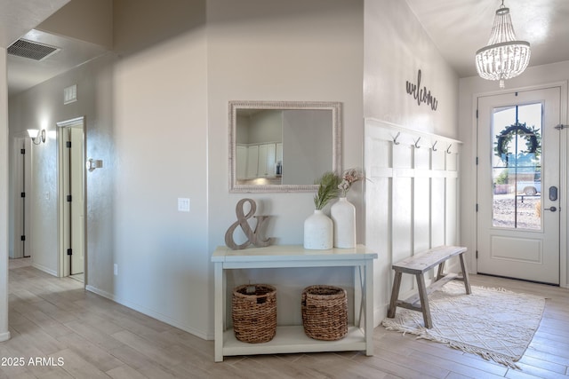 mudroom featuring a notable chandelier and light wood-type flooring