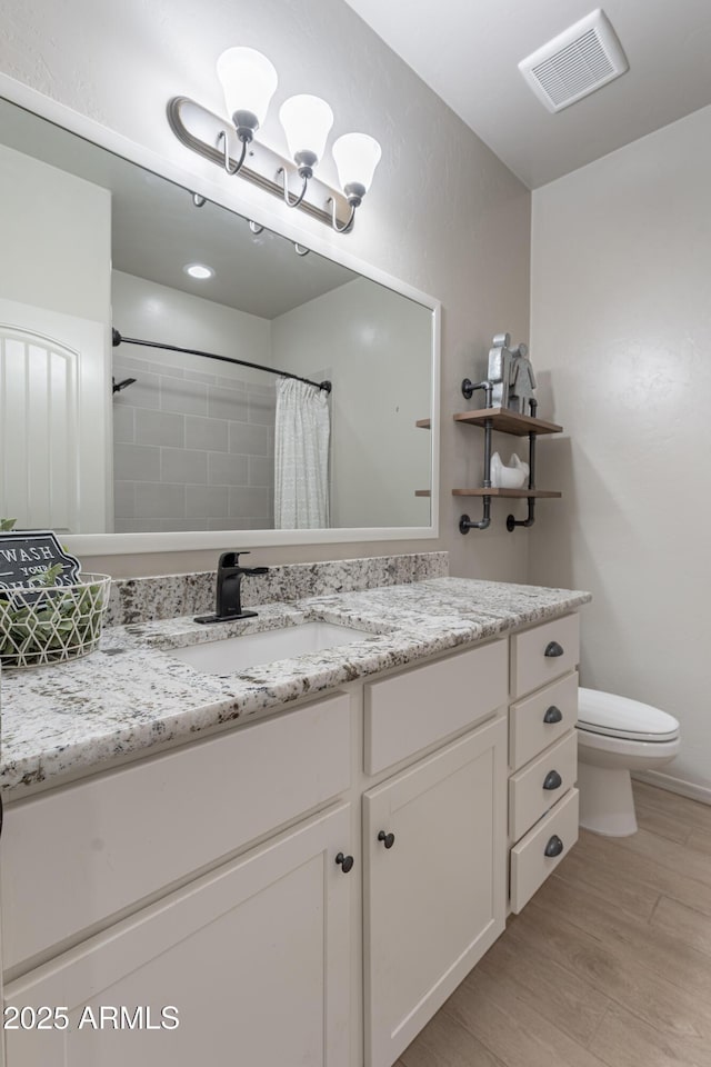 bathroom featuring toilet, vanity, wood-type flooring, and a shower with curtain