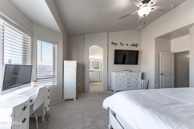 carpeted bedroom featuring ceiling fan, lofted ceiling, and ensuite bath