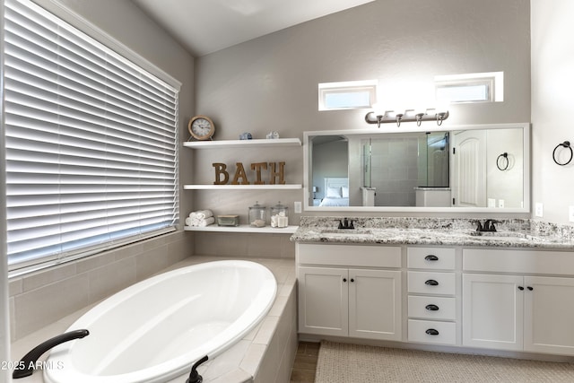 bathroom with plus walk in shower, vanity, and a healthy amount of sunlight