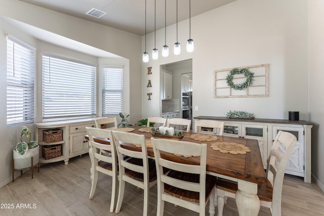 dining room with light wood-type flooring and a wealth of natural light