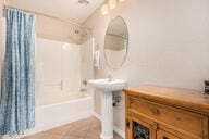 bathroom with shower / tub combo with curtain and tile patterned flooring