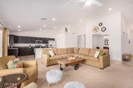 living room featuring ceiling fan and vaulted ceiling