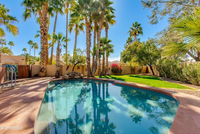 view of swimming pool featuring a lawn, a fenced backyard, and a fenced in pool