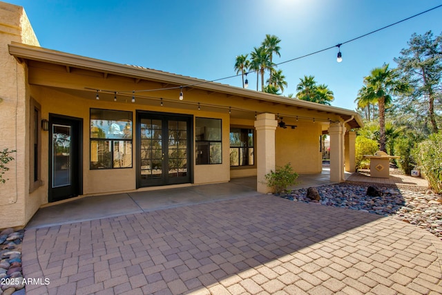 property entrance featuring french doors, a patio, and stucco siding