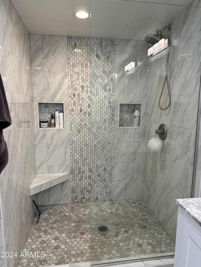 bathroom with vanity and tiled shower