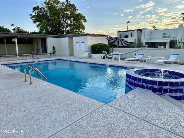 view of swimming pool featuring a hot tub, central AC, and a patio area