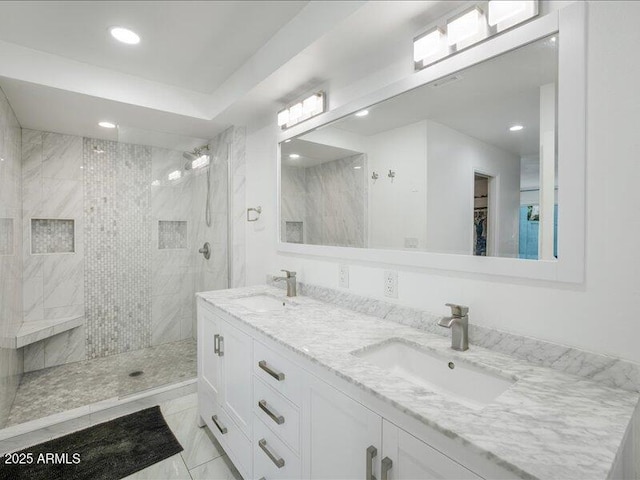 bathroom with vanity and tiled shower