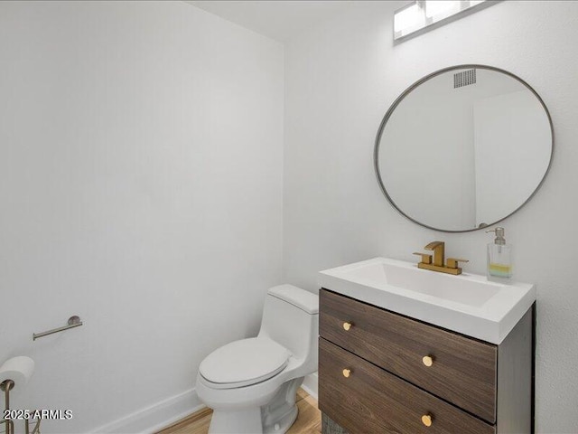 bathroom with vanity, hardwood / wood-style flooring, and toilet