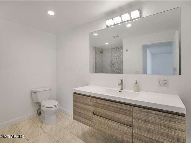 bathroom featuring vanity, a shower with shower door, and toilet