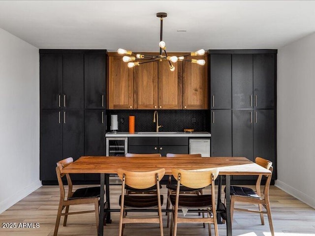 kitchen featuring sink, decorative backsplash, light hardwood / wood-style flooring, and stainless steel dishwasher